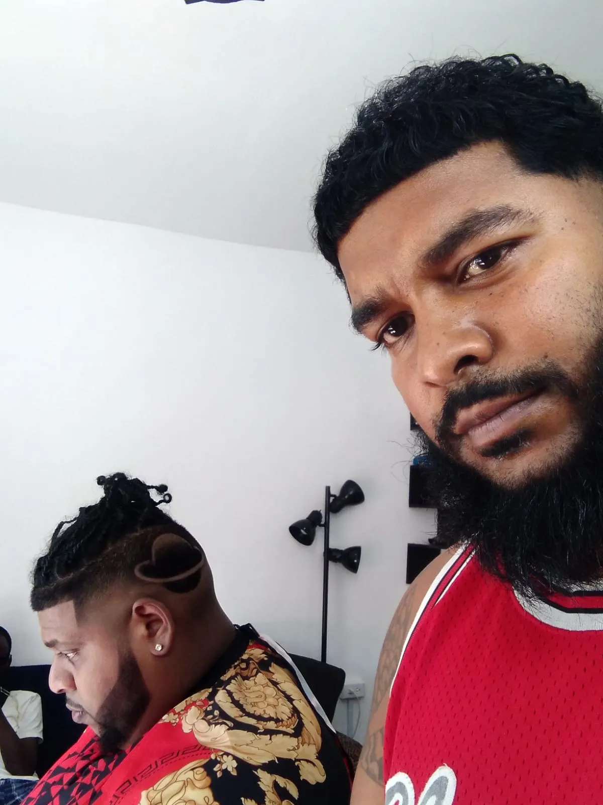 Ryan Cassie in his barbershop in Maraval, with a client in the chair behind him